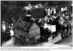 Teilnehmergruppe 12, Wagen der Peter-Vereinigung, Haus mit Storch und Kinderbett.; Kennung: NLJS_Fotoalbum_Winzerfestumzug_1932_009