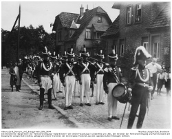 Die Bensheimer Bürgerwehr der Heimatvereinigung "Oald Bensem" bei einem Festumzug in Lindenfels um 1931. Der Gründer der Heimatvereinigung und Kommandant der Bürgerwehr Joseph Stoll (rechts), gefolgt von einem Trommler, der eine Original Trommel aus den napoleonischen Feldzügen mitführt.